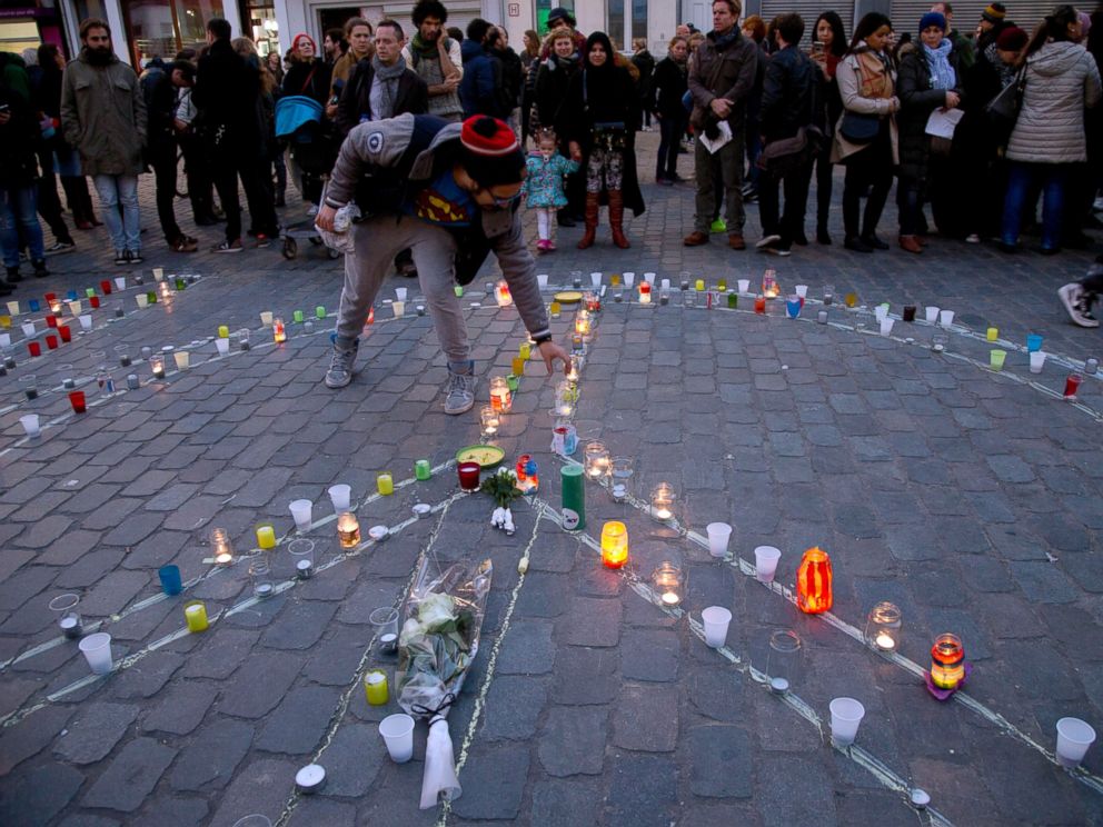 PHOTO: A man lights a candle which forms a peace sign during a candlelight vigil for the Paris attacks in the town square of Molenbeek, Belgium, Nov. 18, 2015.
