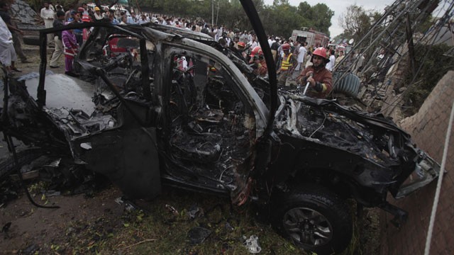 PHOTO: Pakistani officials and rescue workers gather at the site of bombing in Peshawar, Pakistan on Monday, Sept. 3, 2012.