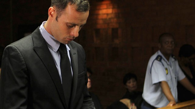 PHOTO: Olympic athlete Oscar Pistorius stands inside the court as a police officer looks on during his bail hearing at the magistrate court in Pretoria, South Africa on Feb. 20, 2013.