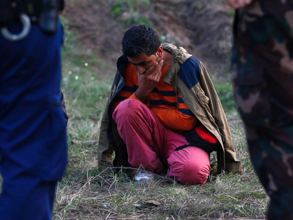 PHOTO: A migrant sits on the ground arrested by Hungarian authorities after he tried to cross the border between Serbia and Hungary in Roszke, Hungary, Sept. 15, 2015.