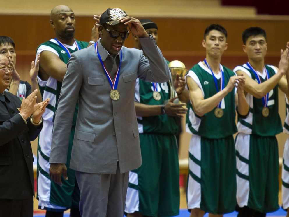 PHOTO: Dennis Rodman tips his hat as U.S. and North Korean basketball players applaud at the end of an exhibition basketball game at an indoor stadium in Pyongyang, North Korea on Jan. 8, 2014.