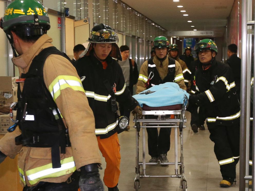 PHOTO: Rescue workers carry an injured person on a stretcher after a ventilation grate was collapsed at an outdoor theater in Seongnam, south of Seoul, South Korea, on Oct. 17, 2014.