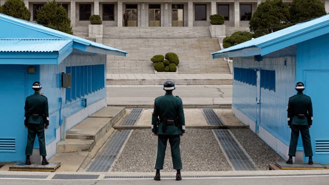 PHOTO: A North Korean soldier, center top, looks at the southern side as South Korean soldiers stand guard at the border village of Panmunjom, which has separated the two Koreas since the Korean War, in Paju, north of Seoul, South Korea on April 10, 2013.