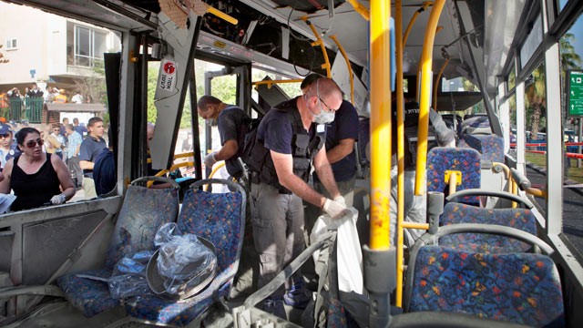PHOTO: Israeli police officers examine a destroyed bus at the site of a bombing in Tel Aviv, Israel, Nov. 21, 2012.