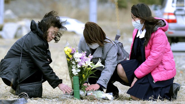 PHOTO: Yoko Yasuda, center, offers flowers where her parents' house used to stand in Rikuzentakata, Iwate prefecture, northern Japan, March 10, 2013.