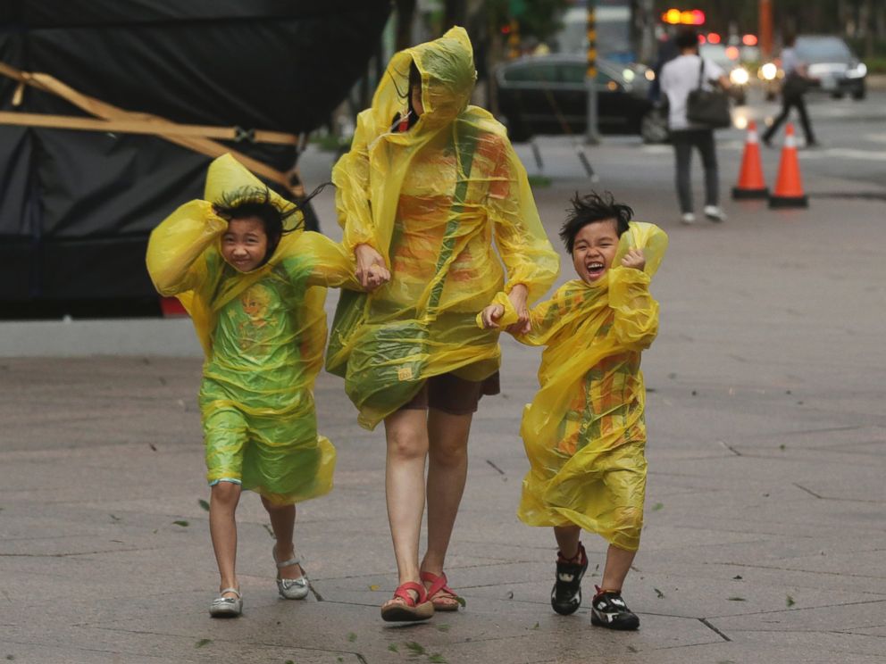 PHOTO: A woman and children brave the strong winds from Typhoon Soudelor in Taipei, Taiwan, Aug. 7, 2015.