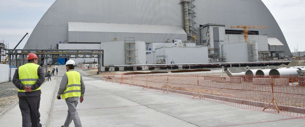 PHOTO: Workers walk next to the New Safe Confinement over the fourth block of the Chernobyl nuclear plant on April 26, 2017, the 31st anniversary of the Chernobyl disaster.