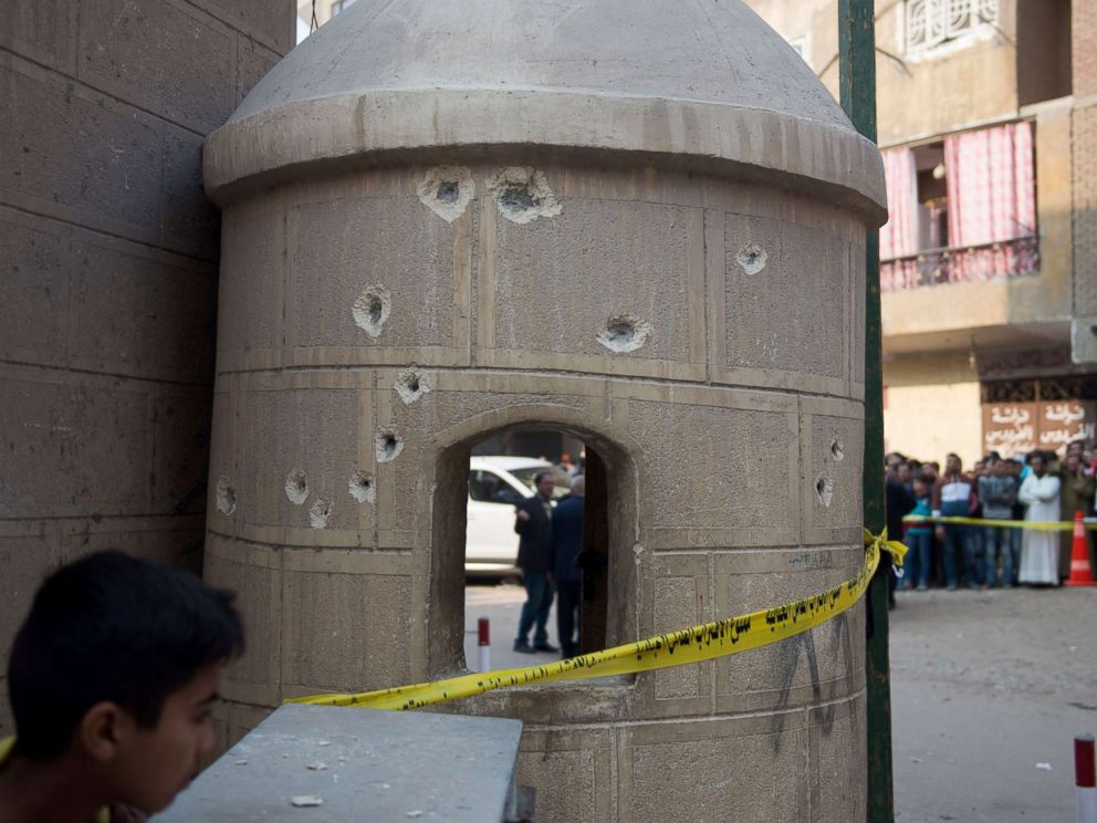 PHOTO: People stand near construction with bullet holes outside Mar Mina church following an attack on the church in the district of Helwan, southeastern Cairo, Dec. 29, 2017.