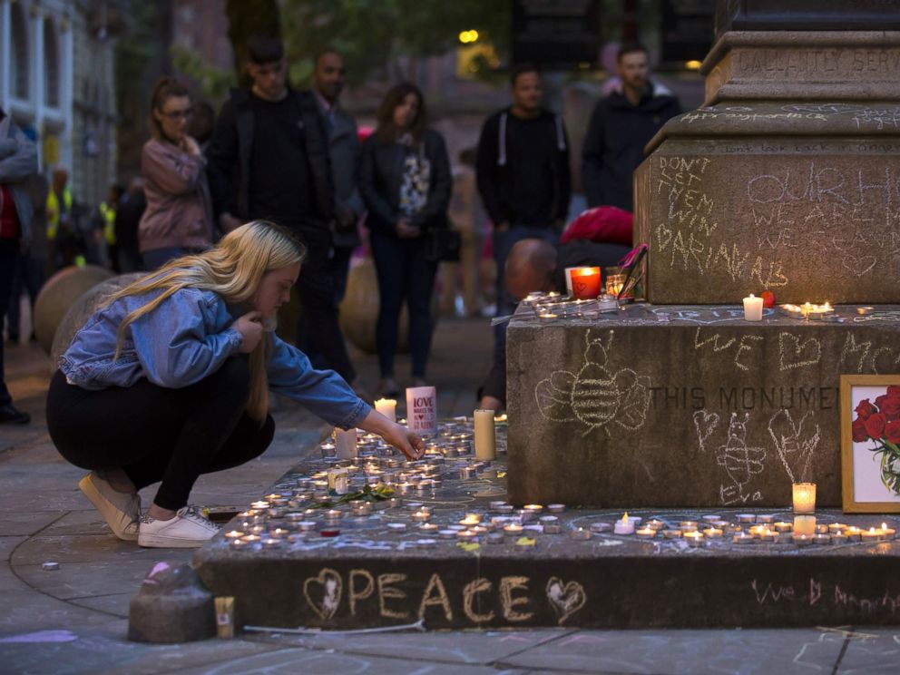 PHOTO: A member of the public lights memorial candles before a vigil in St Anns Square in Manchester, north west England on May 29, 2017, placed in tribute to the victims of the May 22 terror attack at the Manchester Arena.