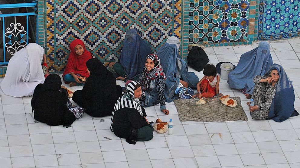 PHOTO: Afghan women wait to break their fast during the holy month of Ramadan at the Hazrat-e Ali shrine in Mazar-i Sharif in northern of Afghanistan on July 17, 2013.