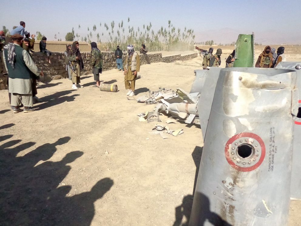 PHOTO: In this photograph taken on Oct.13, 2015, Afghan Taliban militants gather around parts of a US F-16 aircraft that was struck over in Sayid Karam district of eastern Paktia province.