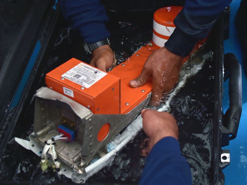 PHOTO: Indonesian divers onboard the Indonesian navy vessel KRI Banda Aceh handle the Flight Data Recorder of the AirAsia flight QZ8501 after it was retrieved from the Java Sea on Jan. 12, 2015.