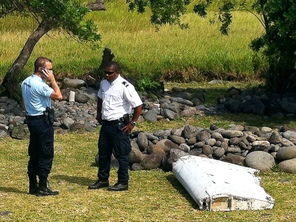 PHOTO: Policemen stand next to a piece of debris from an unidentified aircraft, July 29, 2015, found in the coastal area of Saint-Andre de la Reunion, in the east of the French Indian Ocean island of La Reunion