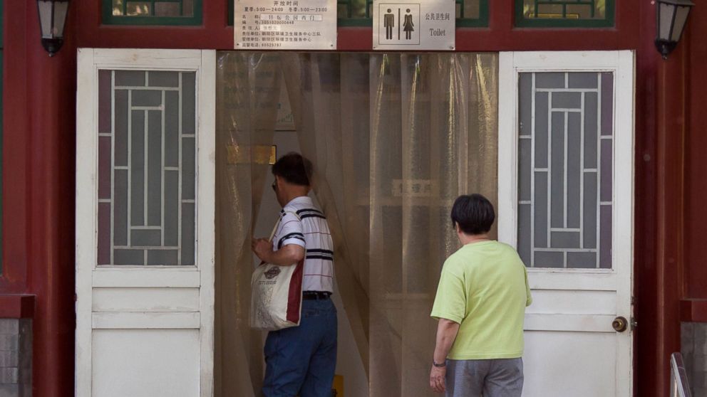 PHOTO: Men walk into a public toilet in Beijing, China on May 24, 2012.