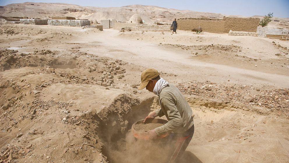 PHOTO: Looters dig through the sand, sifting and unearthing Roman and Pharaonic antiquities to sell on June 26, 2013 in Sheikh Ibada, Egypt.