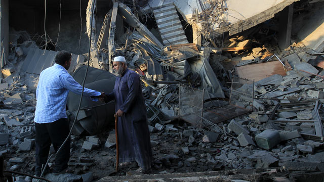PHOTO: Palestinians walk past the debris of a destroyed home following an Israeli air strike in Gaza City, on November 19, 2012.