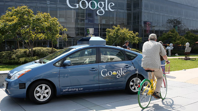 PHOTO: A bicyclist rides by a Google self-driving car at the Google headquarters on September 25, 2012 in Mountain View, California.