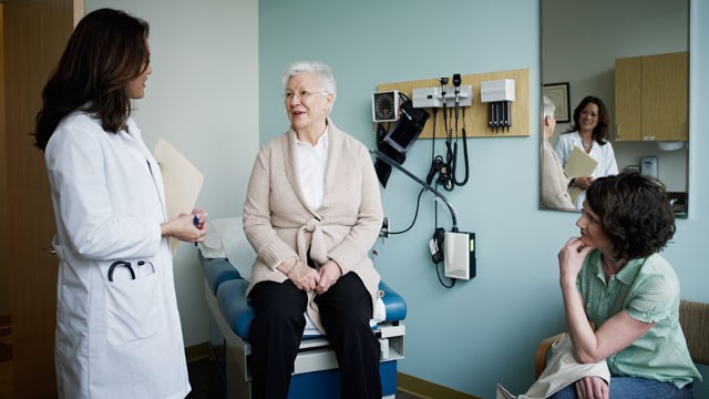 PHOTO: Mature female patient in exam room with doctor.