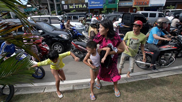 PHOTO: Acehnese people run shortly after a powerfull earthquake hit western coast of Sumatera in Banda Aceh, April 11, 2012.