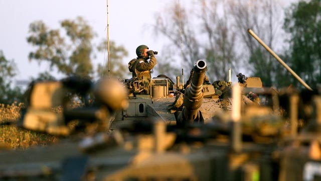 PHOTO: An Israeli soldier looks through binoculars from the top of his Merkava tank during a drill near the border with Syria at the Israeli-annexed Golan Heights, May 6, 2013.