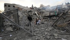 PHOTO: Palestinian Hamas security members inspect the destroyed office building of Hamas Prime Minister Ismail Haniya in Gaza City on November 17, 2012.