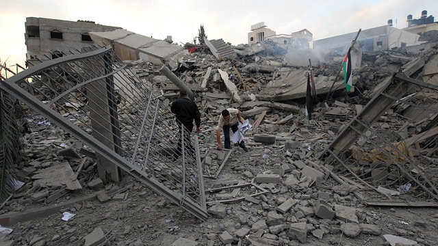 PHOTO: Palestinian Hamas security members inspect the destroyed office building of Hamas Prime Minister Ismail Haniya in Gaza City on November 17, 2012.