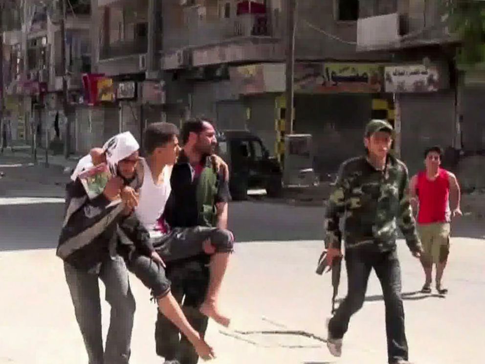 PHOTO: An image grab taken from AFP TV on August 5, 2012 shows Syrian rebels carrying a wounded man in the Salaheddin district of the northern Syrian city of Aleppo on Aug. 3, 2012.