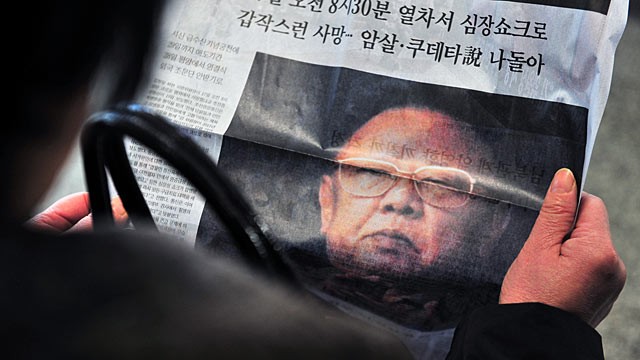 PHOTO: A woman reads a copy of an extra edition newspaper reporting the death of Kim Jong Il.