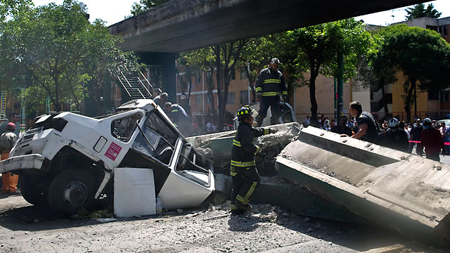 PHOTO: Firefighters work to remove a bus damaged by a bridge which collapsed following a strong quake that hit Mexico, March 20, 2012.