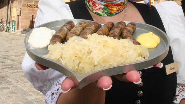 PHOTO: A waitress at Bratwursthausle, displays the Nuremburg Bratwurst dish "Sex mit Kraut" in Nuremberg, Germany, June 9, 2006.