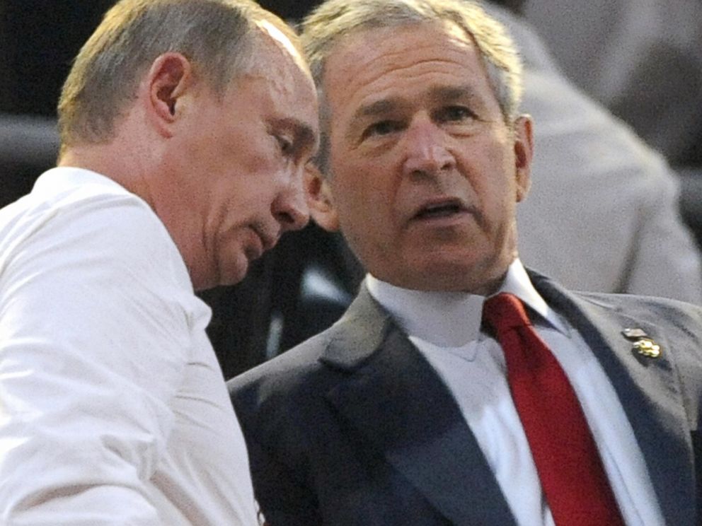 PHOTO: Russian Prime Mininster Vladimir Putin (L) talks with US President George W. Bush at the start of the opening ceremony of the 2008 Beijing Olympic Games in Beijing on August 8, 2008.