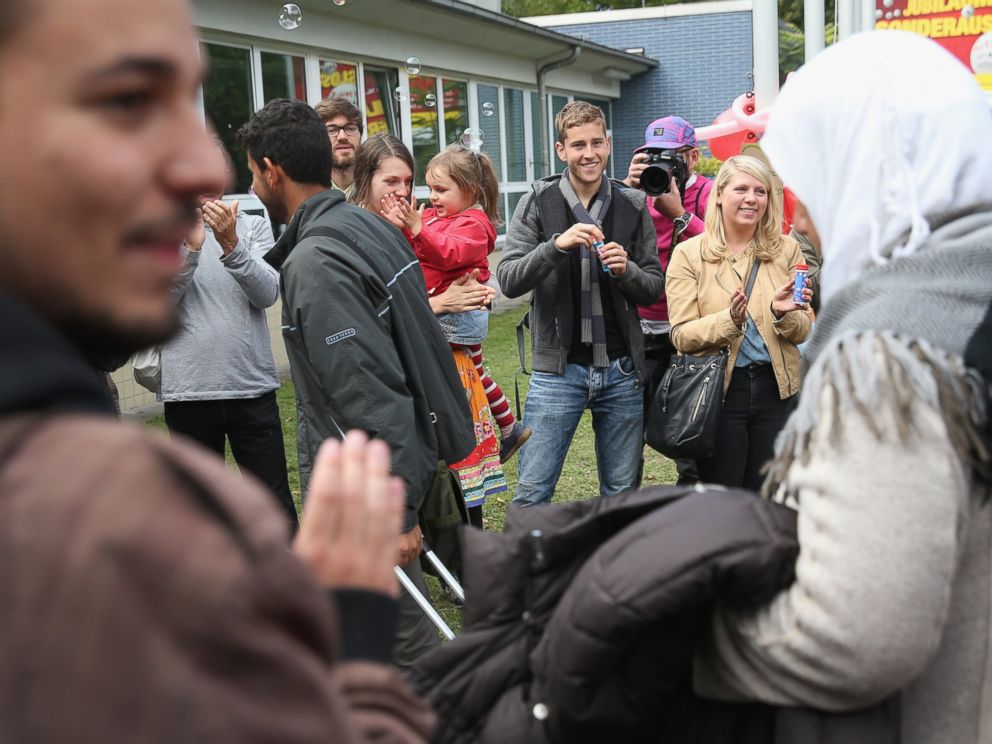 PHOTO: Refugees who arrived by train are greeted by locals welcoming them with soap bubbles and balloons at the Jahn-Sporthalle gymnasium in Berlin, Sept. 8, 2015.