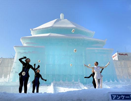 taiwanese dancers perform in front of a large snow sculpture of taipei