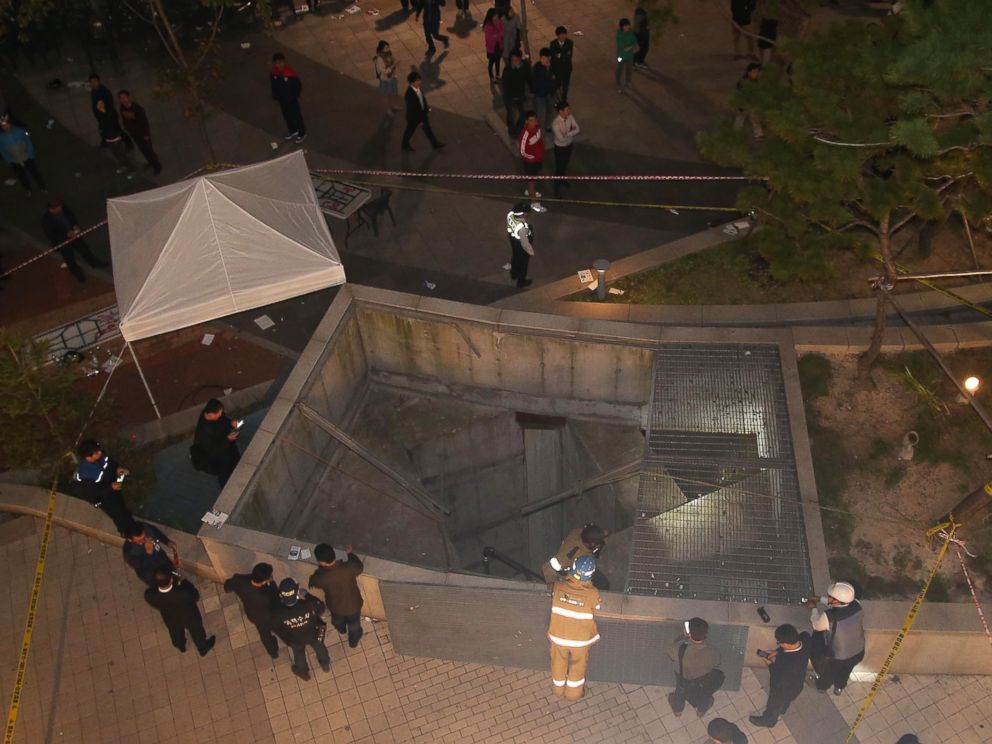 PHOTO: Rescue workers stand around a collapsed ventilation grate on Oct. 17, 2014 in Seongnam, South Korea.
