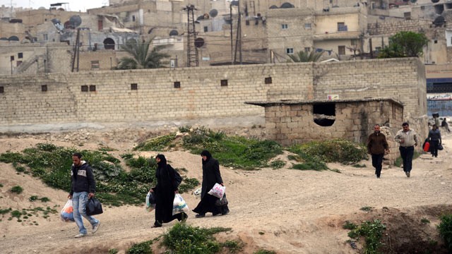 PHOTO: Syrians carry their belongings as they leave Sheikh Maqsud neighborhood in Aleppo, April 4, 2013.