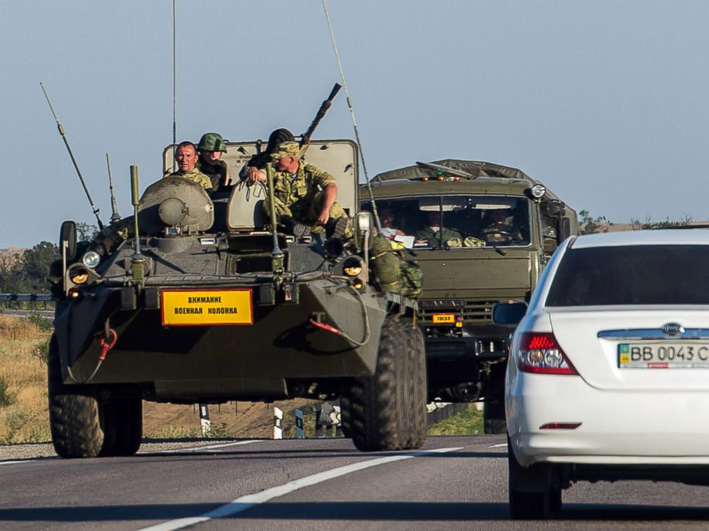 PHOTO: A Russian armored personnel carrier leads a column of military vehicles on a road near the town of Kamensk-Shakhtinsky in the Rostov region, some 30 km from the Russian-Ukrainian border, on August 15, 2014.
