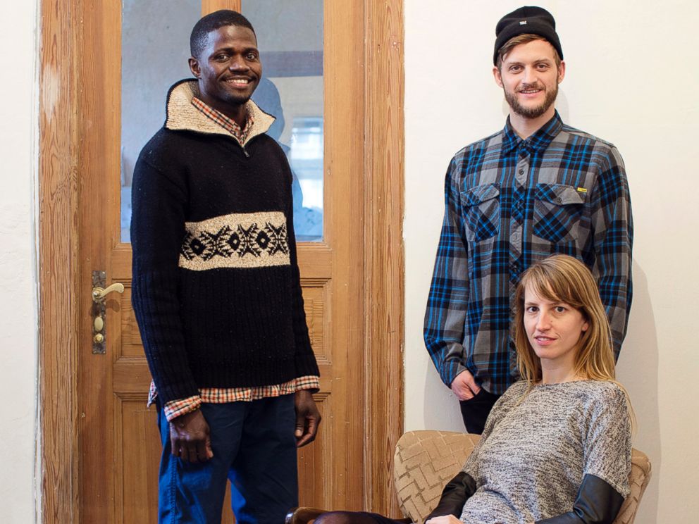 PHOTO: Refugees Welcome founders Mareike Geiling and Jonas Kakoschke pose with Bakary, a refugee from Mali that they hosted, in an undated handout photo.