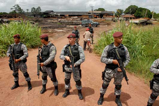 amazon logging. Brazilian federal policemen stand guard at the entrance to 