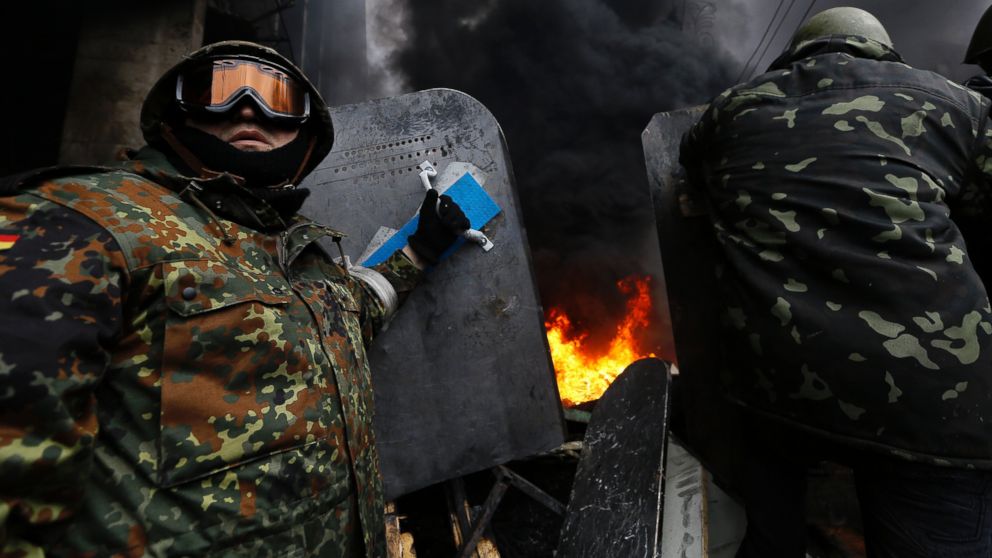 PHOTO: Anti-government protesters prepare to advance over a burning barricade in Kievs Independence Square, Feb. 20, 2014.