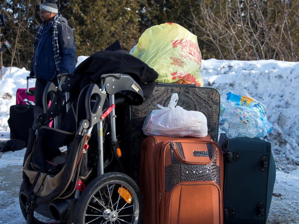 PHOTO: A man claiming to be from Sudan is detained with his familys luggage by a U.S. border patrol officer after his family crossed the U.S.-Canada border into Hemmingford, Canada, from Champlain in New York, Feb. 17, 2017.