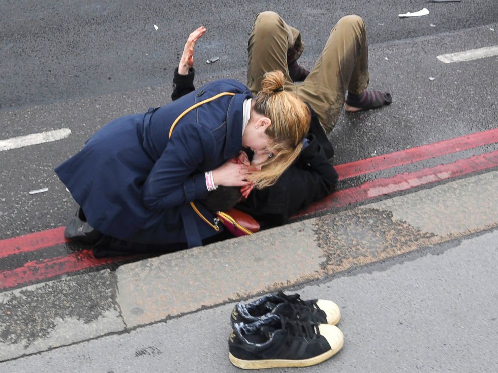 PHOTO: A woman assists an injured person after an incident on Westminster Bridge in London, March 22, 2017.