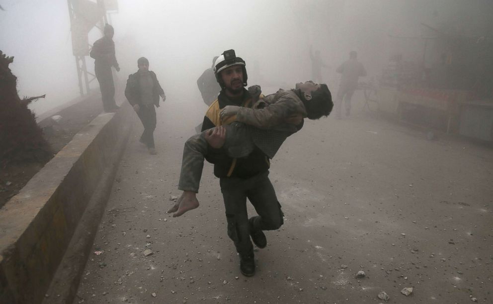 PHOTO: A volunteer from the Syrian Civil Defence, known as the White Helmets, carries a wounded boy after digging him out of the rubble following an air strike in the besieged rebel-held Eastern Ghouta area near Damascus, Syria, Jan. 9, 2018.