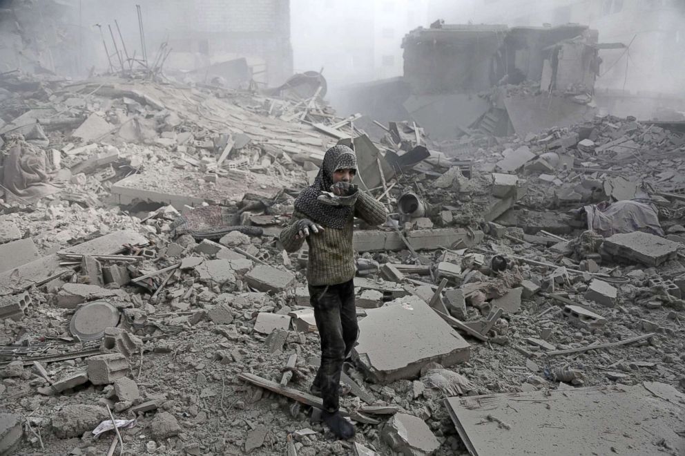 PHOTO: A girl appears from the rubble holding her shoe following an air strike in the besieged rebel-held Eastern Ghouta area near Damascus, Syria, Jan. 9, 2018.