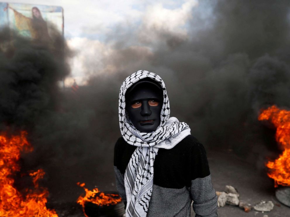 PHOTO: A Palestinian demonstrator stands near burning tires during clashes with Israeli troops at a protest against President Donald Trumps decision to recognize Jerusalem as the capital of Israel, near the West Bank city of Nablus, Dec. 15, 2017. 