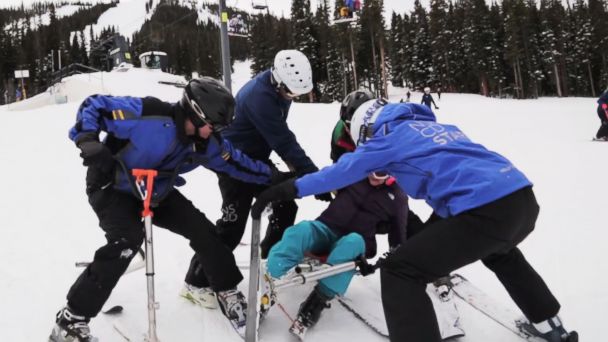 Kati Leasure is helped back up by a team of supporters from the National Sport Center for Disabled and her sister Amy.