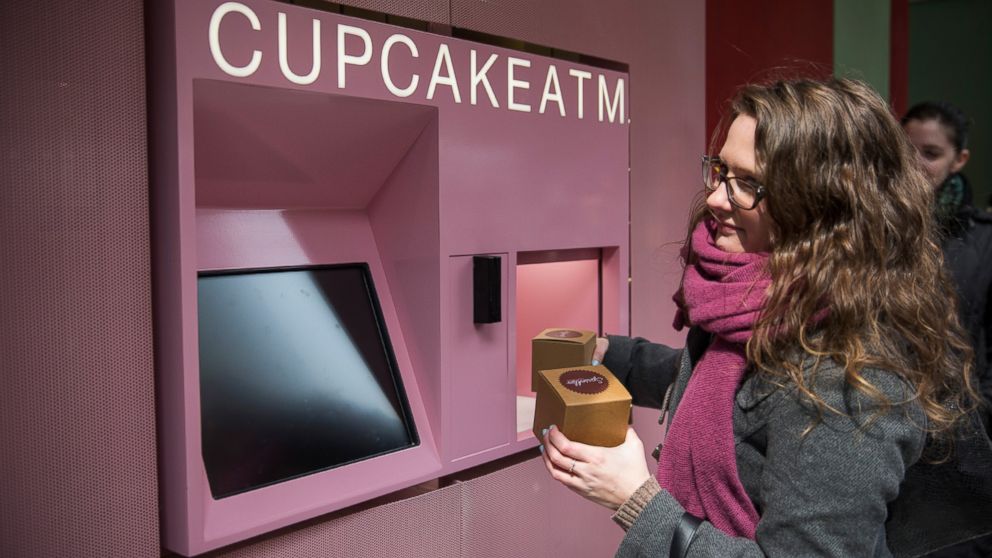 PHOTO: A woman takes her order after using the "Cupcake ATM" created by Sprinkles Cupcakes