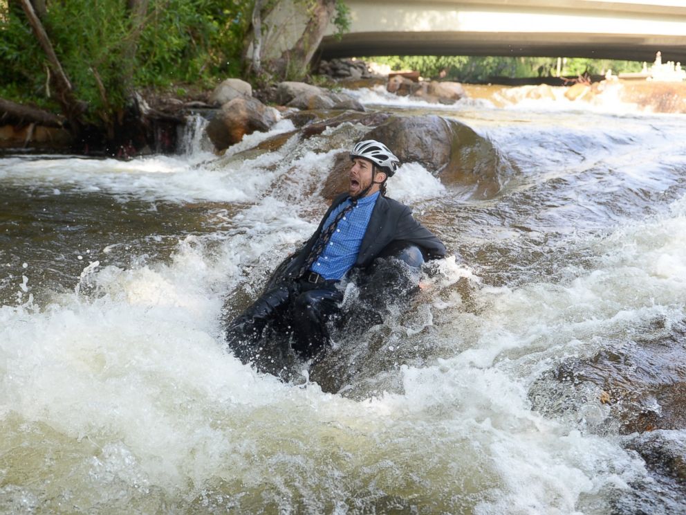PHOTO: Quayle Hodek, dressed in a suit and tie, floats down Boulder Creek during Boulders Tube to Work Day, July 15, 2014.