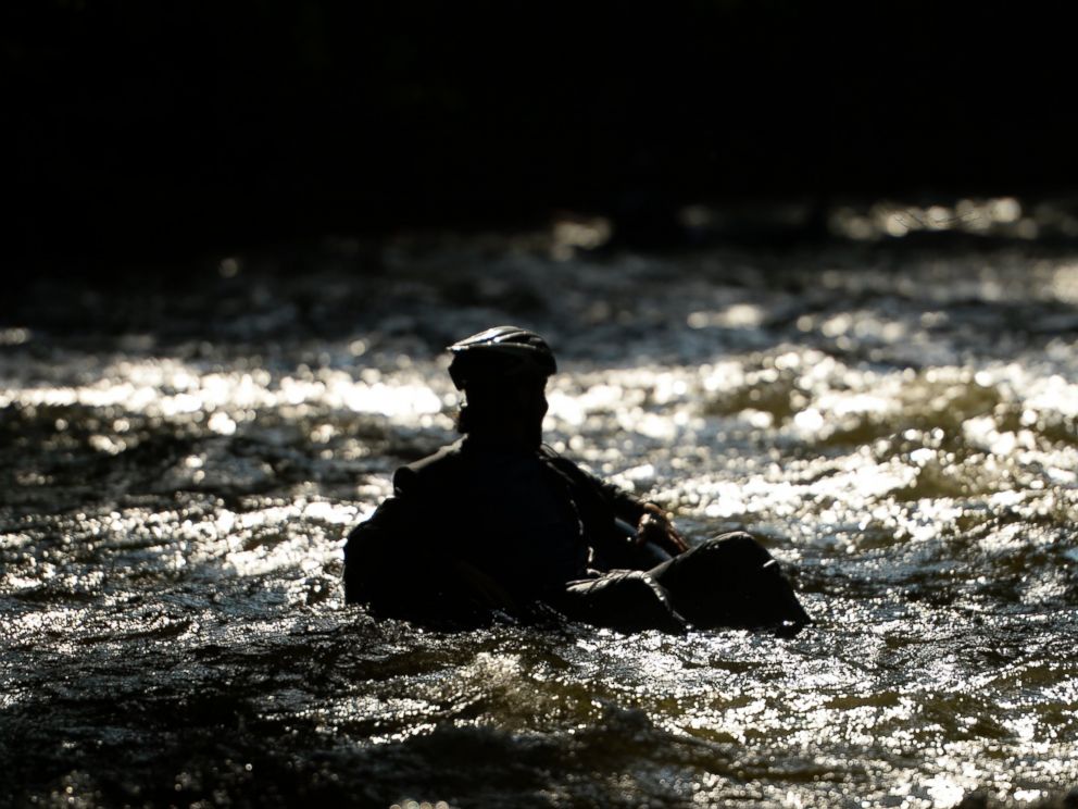 PHOTO: Quayle Hodek, dressed in a suit and tie, floats down Boulder Creek during Boulders Tube to Work Day, July 15, 2014.
