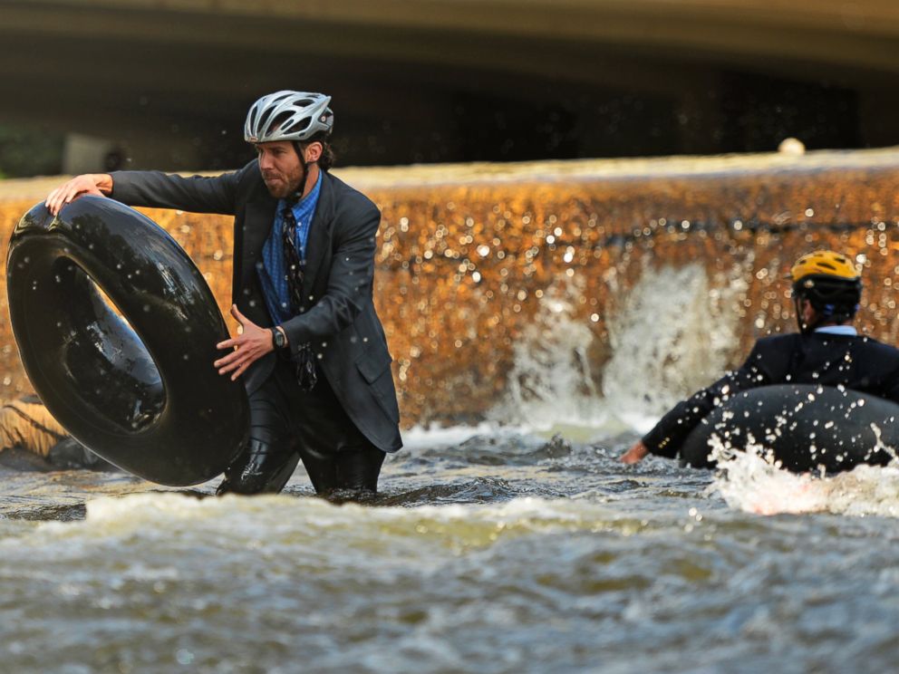PHOTO: Quayle Hodek, dressed in a suit and tie, hops back on his tube during Boulders Tube to Work Day, July 15, 2014.