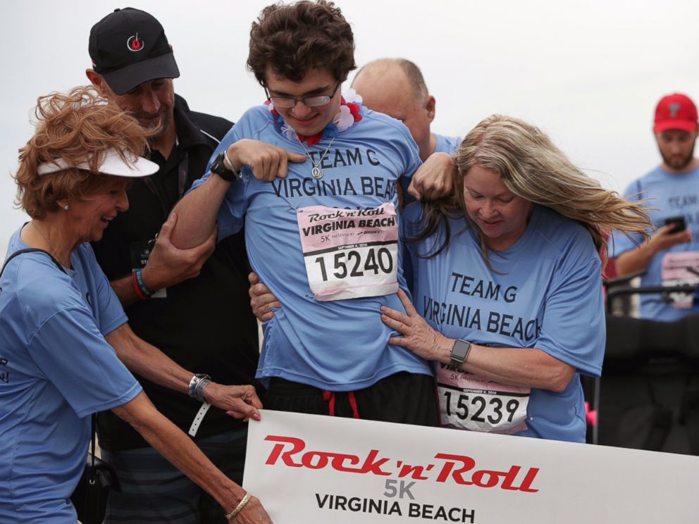 PHOTO: Greg Kenney Jr., who suffered a traumatic brain injury last year, walked across the finish line at the Rock n Roll Half Marathon in Virginia Beach. 